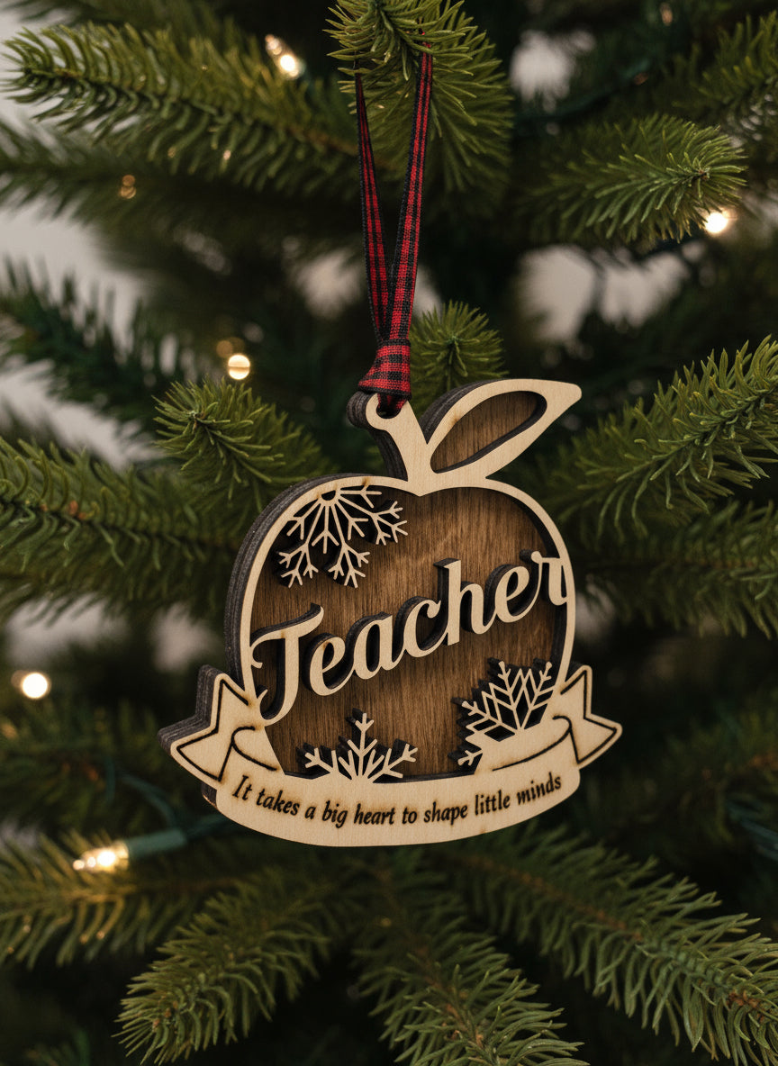 Wooden ornament shaped like an apple with 'Teacher' text on a Christmas tree.