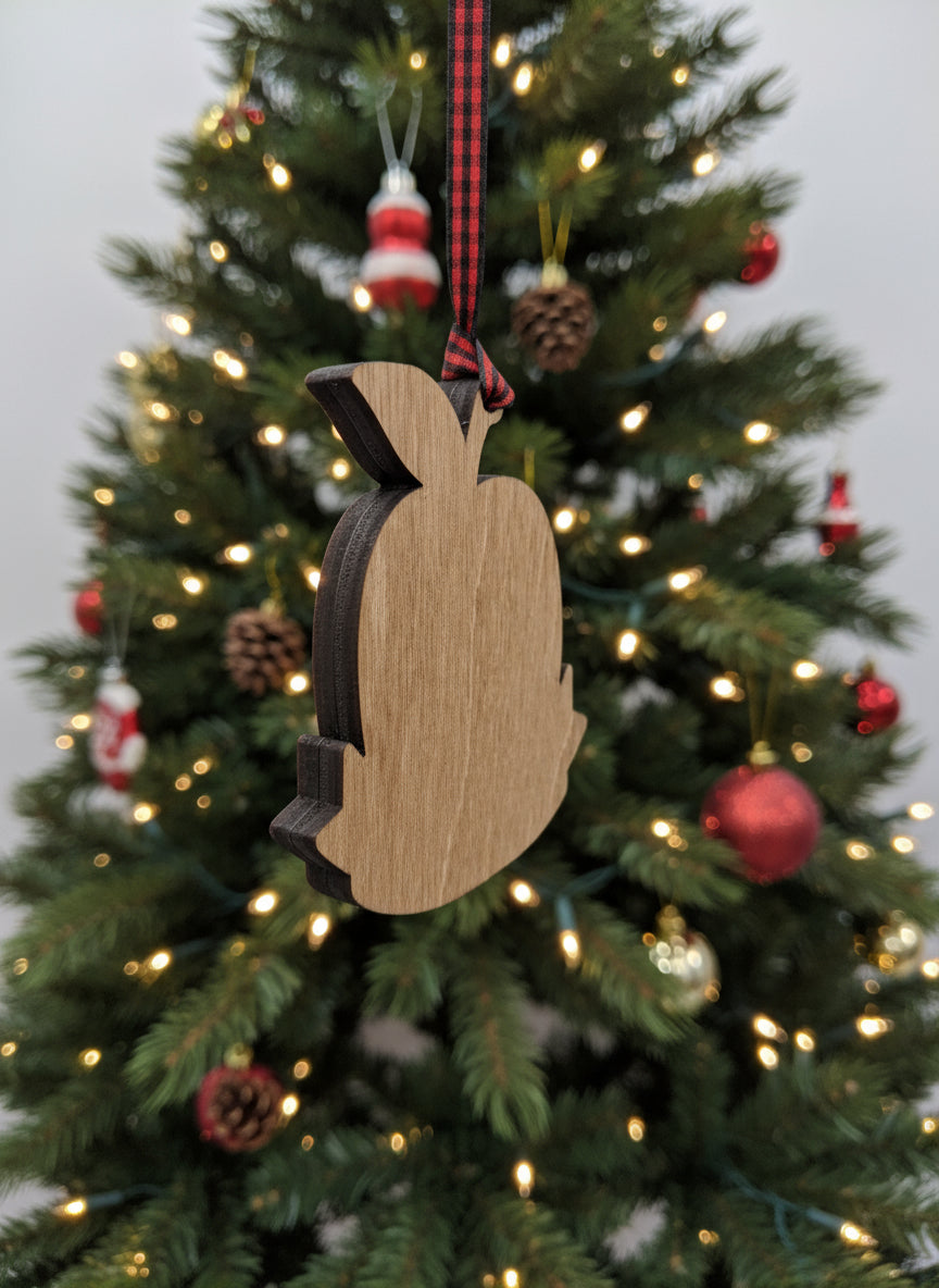 Wooden Christmas ornament shaped like an apple on a tree with lights and decorations.